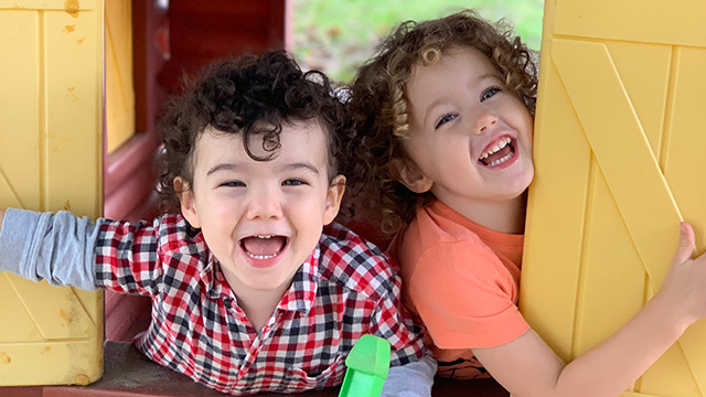 Two children laughing and playing outside