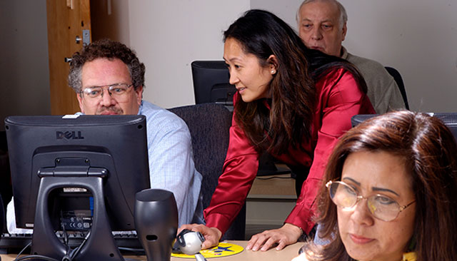 Staff members use computers together.