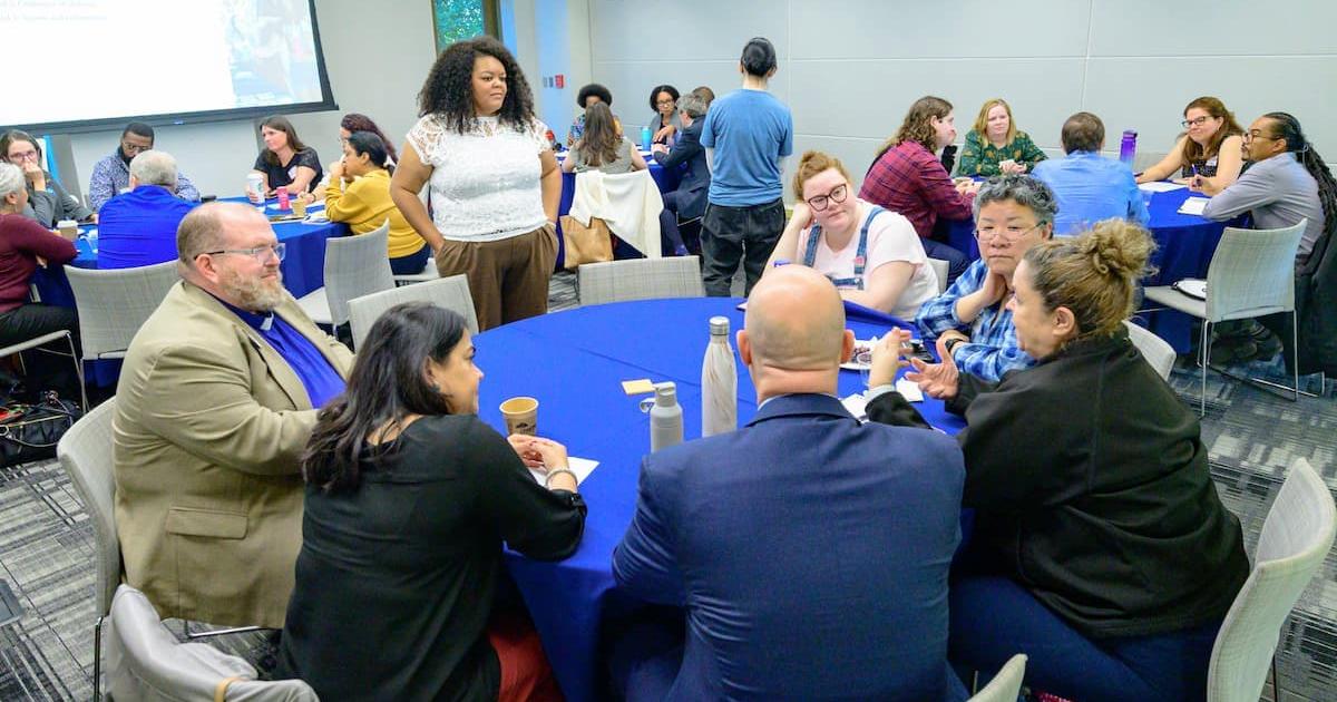 Individuals interacting around a table