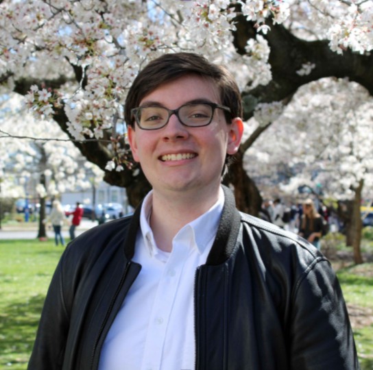 Student in front of Cherry Blossoms