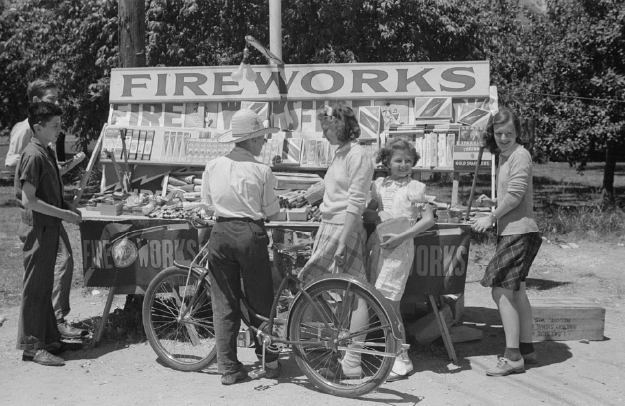 people at a fireworks booth in the mid-20th century