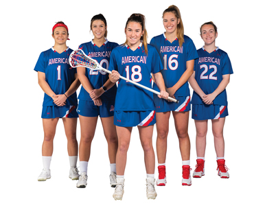 Kendall Goldblum holds a lacrosse stick and stands in front of four teammates