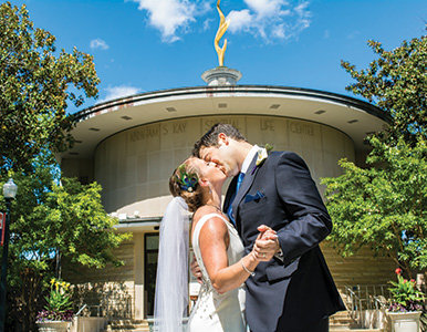 Lisa Suda and Justin Berger in front of Kay on their wedding day