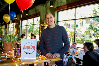 Lenard Zohn in a restaurant with children and balloons