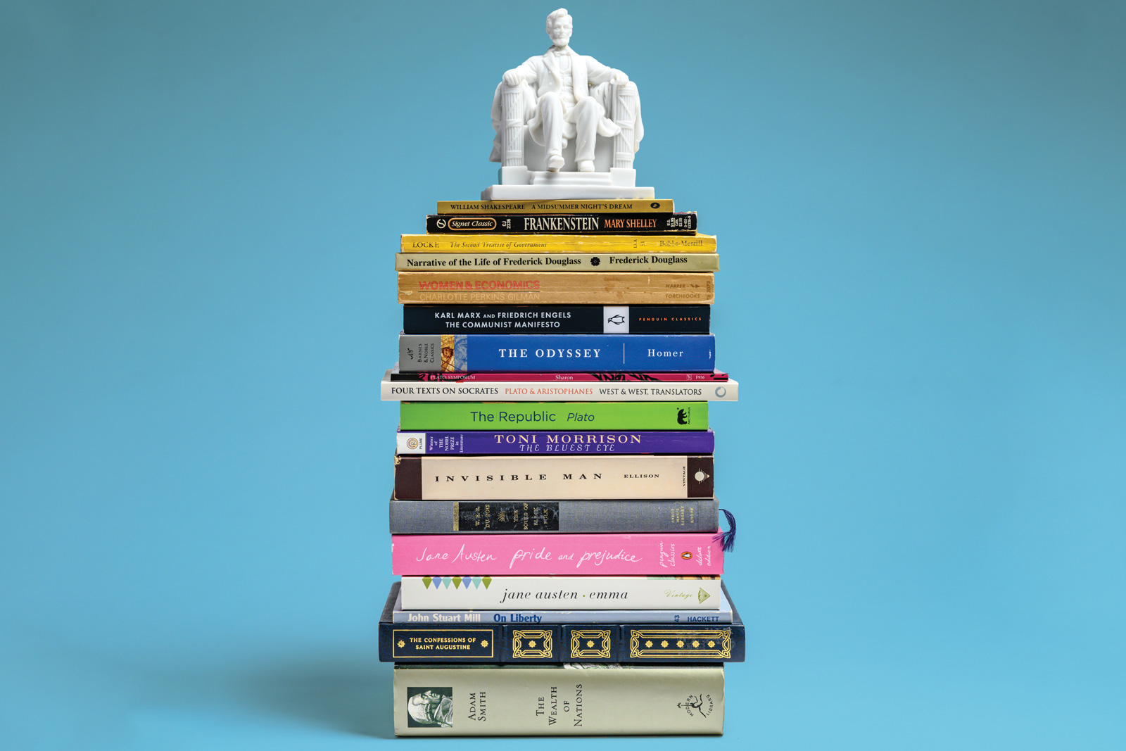 Stack of classic texts with a statue of Abraham Lincoln on top