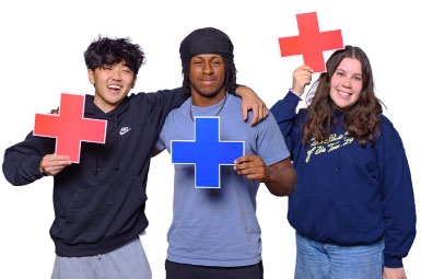 three AU students holding plus signs