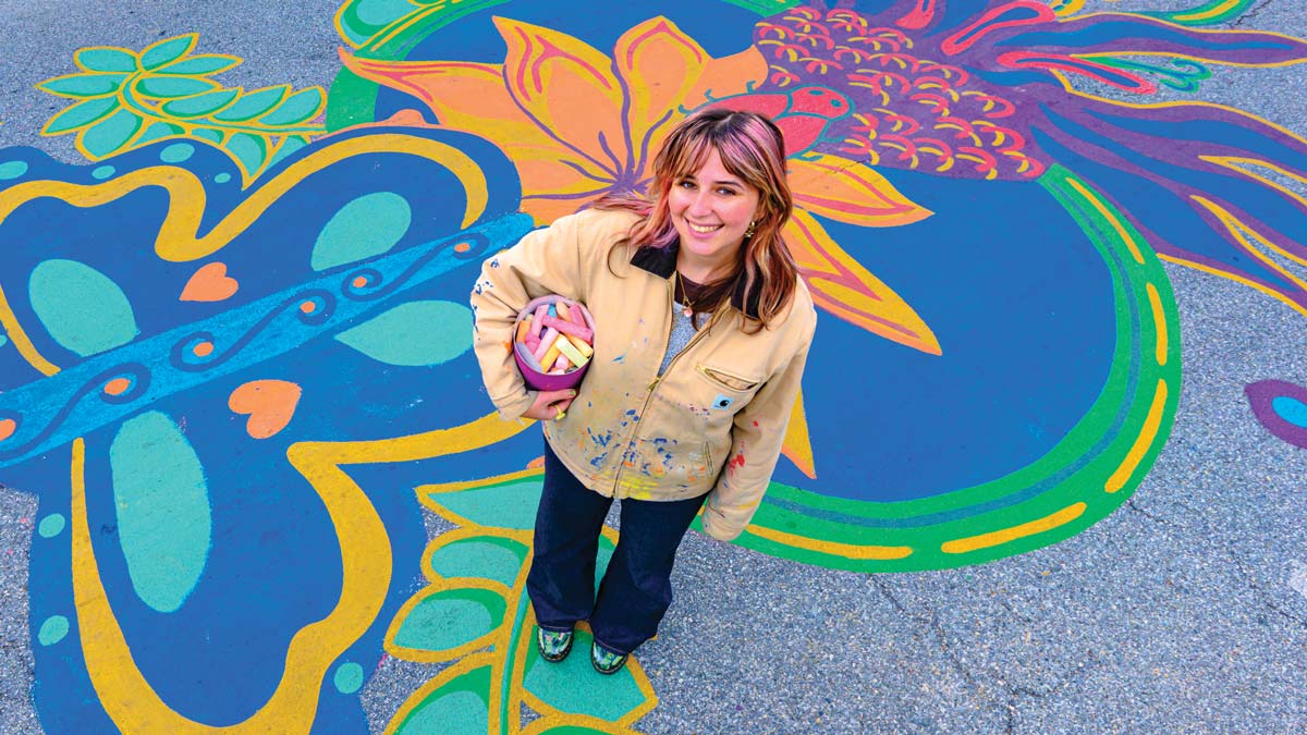 Samantha Hamilton stands before a colorful street mural