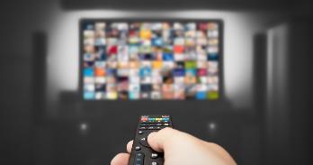 Person holding remote control to change channel