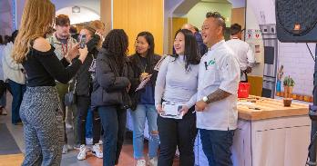 Chef Jet Tila poses with a student after a cooking demonstration at AU.