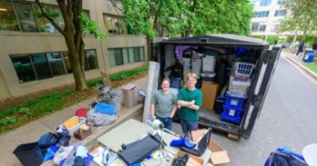 From left, zero waste manager Caroline Boone and Luke Carignan, CAS/BS ’25, BA ’25, stand next to one of the Project Move Out pods. Photo by Jeff Watts.
