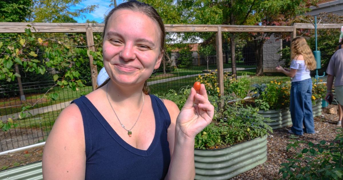 Photo of a student holding a tomato. Photo by Jeff Watts.