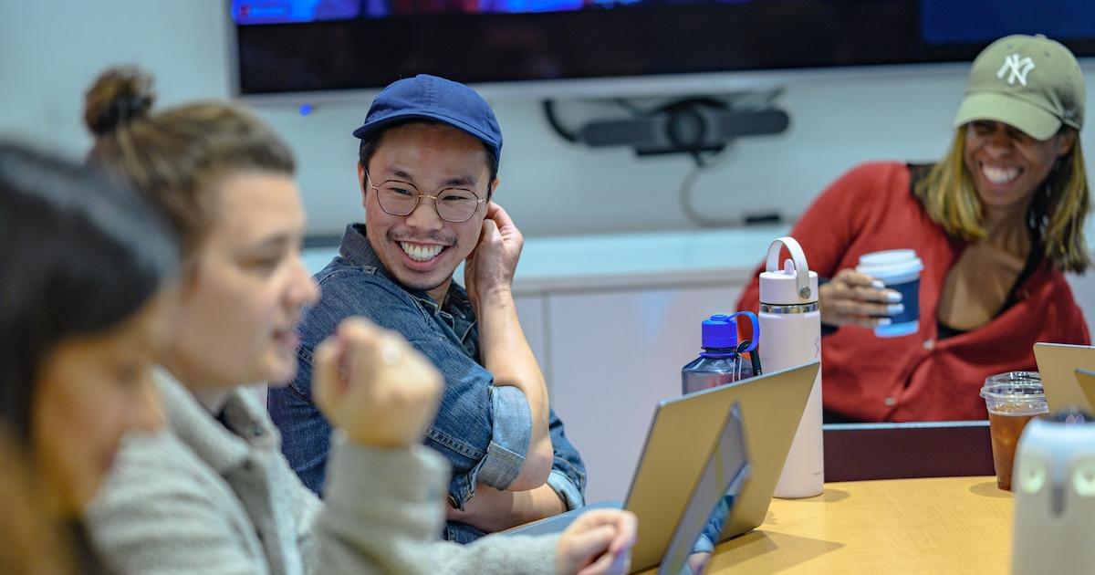 Two producers laugh during an afternoon editorial meeting. Photo by Jeff Watts.