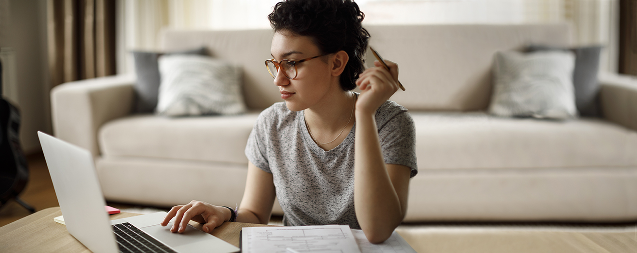 A graduate student studies in her living room