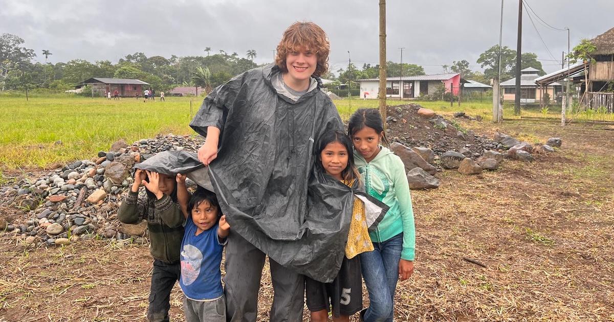 Evan Kwiatkowski poses with children in Ecuador. Photo courtesy of Evan Kwiatkowski.