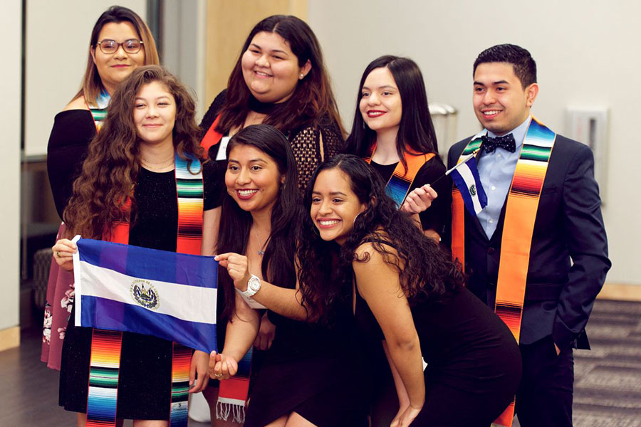 LatinX students pose with El Salvador flag during LatinX Graduation in 2018