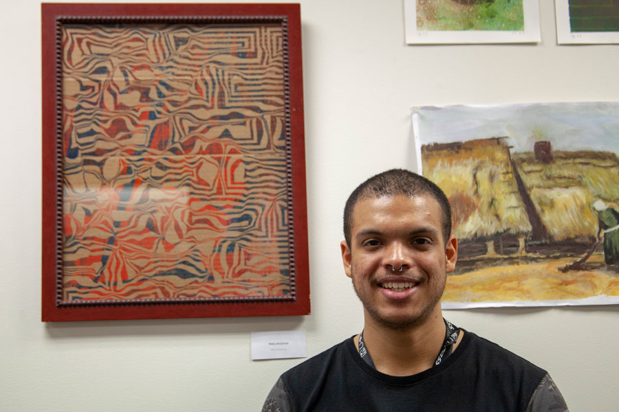 Nieko McDaniel posing in front of his art