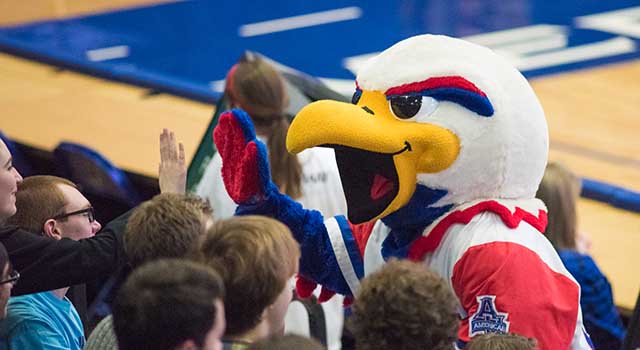 Clawed the Eagle high-fiving students