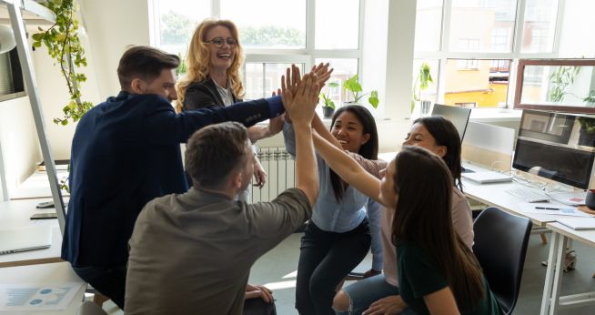 Executive Coaching team giving high fives for establishing a coaching culture at work