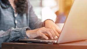 individual typing on laptop