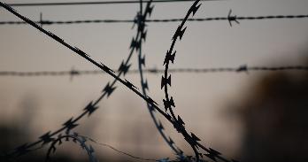 razor wire with barbed wire in the background