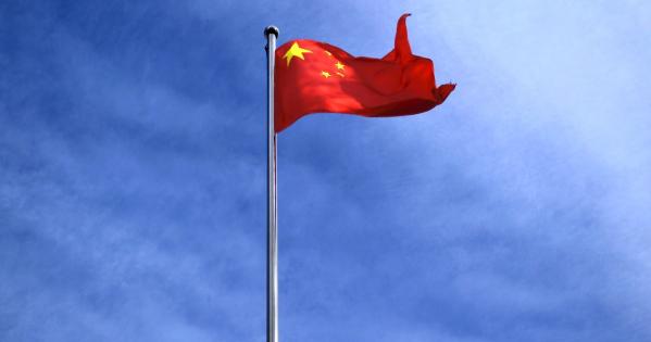 the chinese flag on a flagpole looking up to the sky