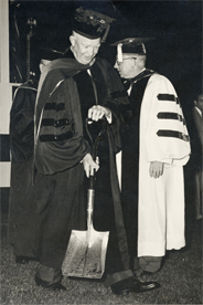 Eisenhower holds shovel to break ground for the SIS building in 1957