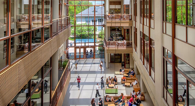 The sunny atrium of SIS busy with people.
