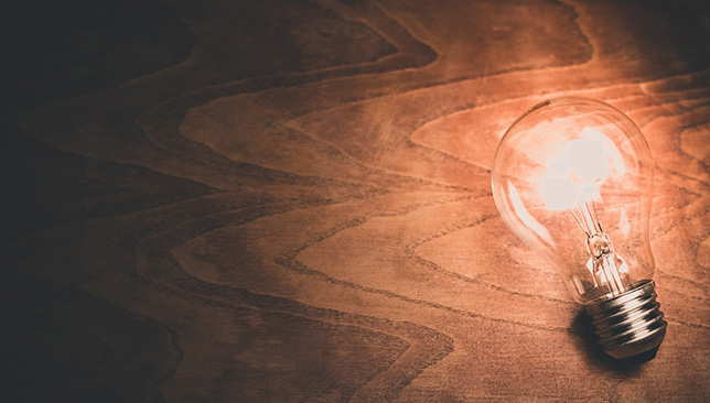 lightbulb lit up on wooden table