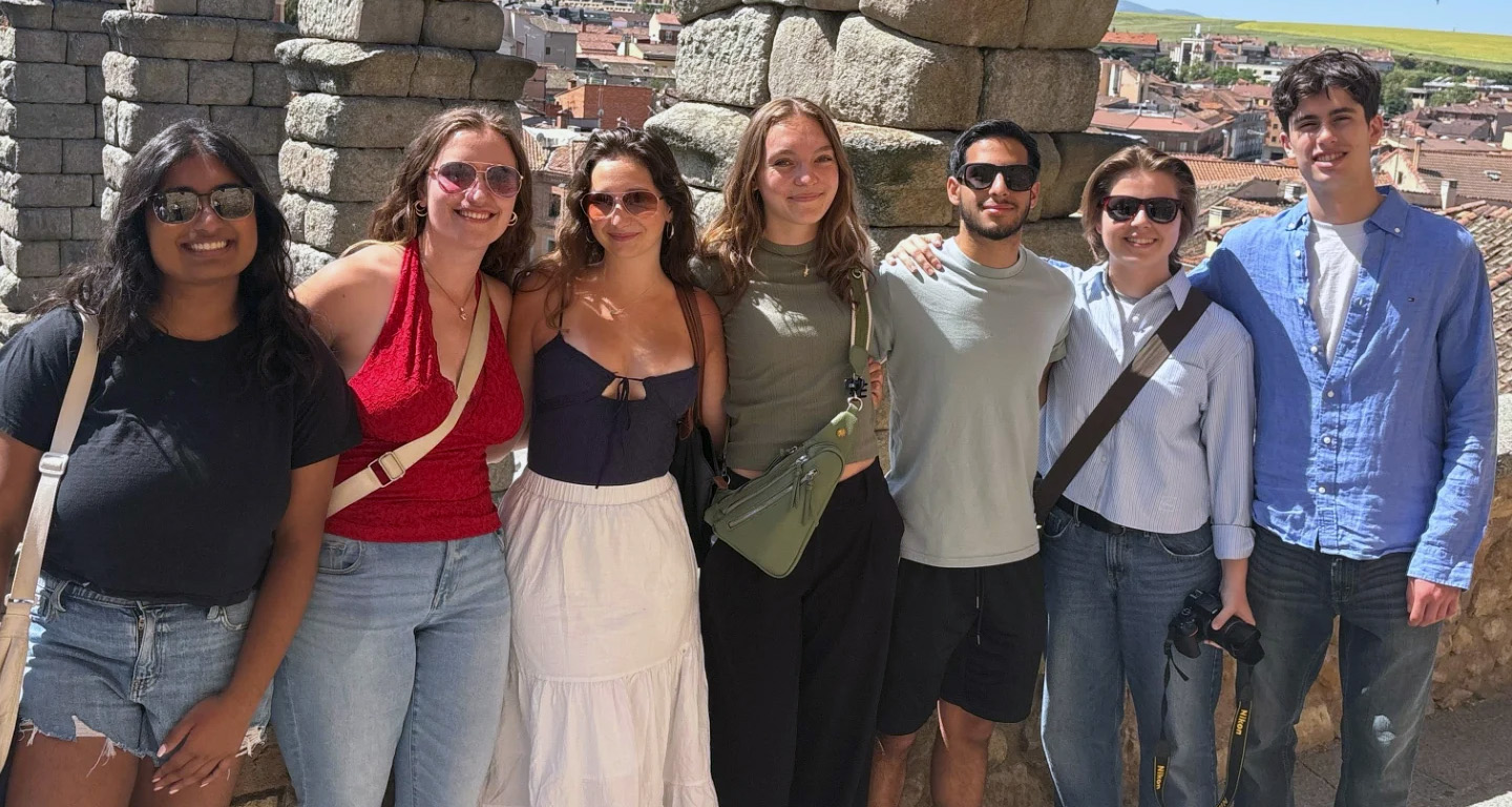 A group of Global Scholars smile with a Spanish landscape in the background.