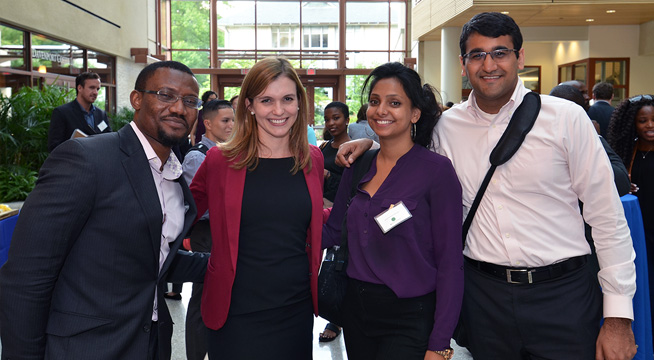 Four students smile and pose for a photo at an SIS online graduate student orientation.