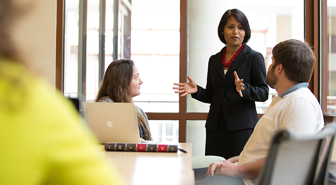 An SIS professor speaks to students in a classroom.