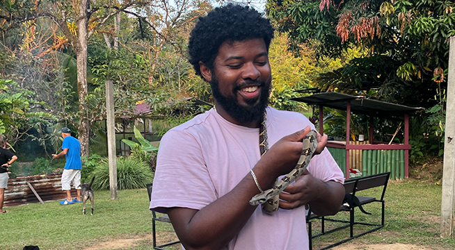 Student holding a snake while studying abroad.