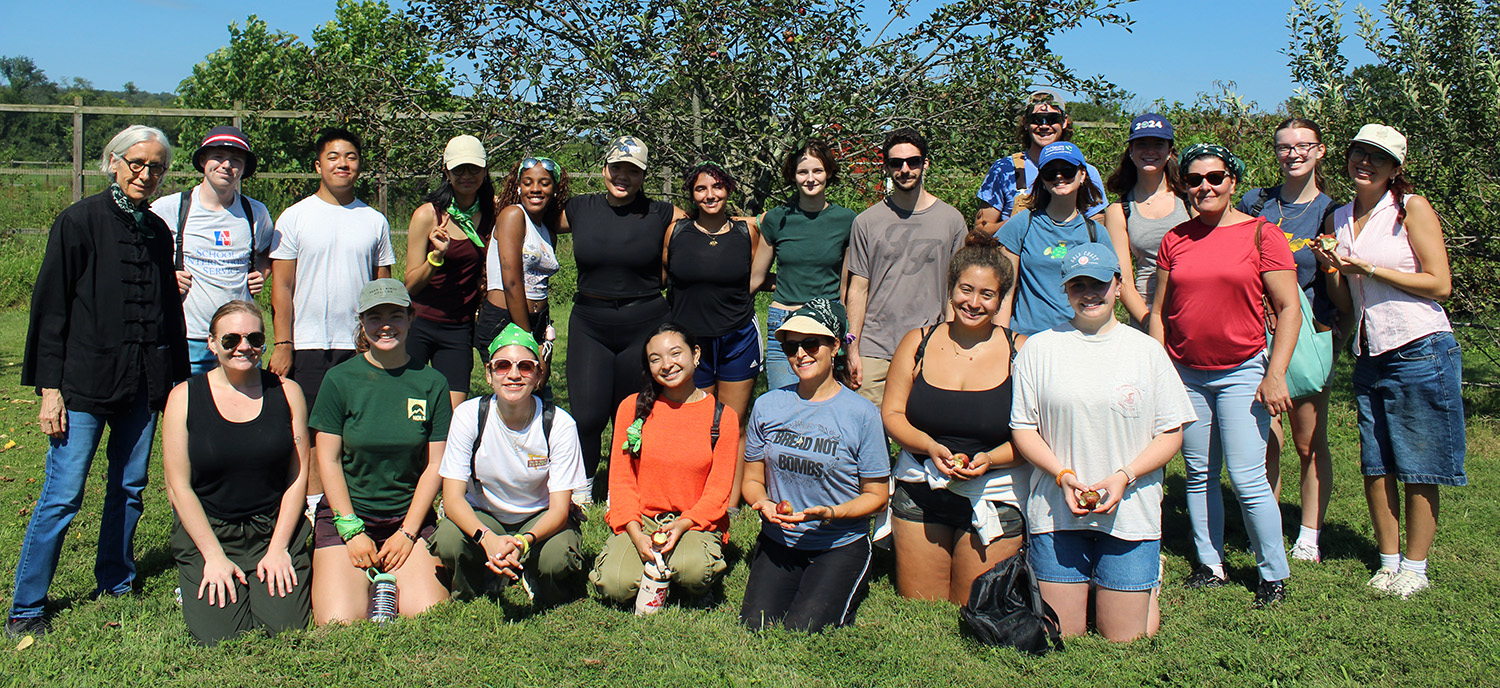 A group of Earth Scholars pose for a photo while working outdoors on a sunny day.