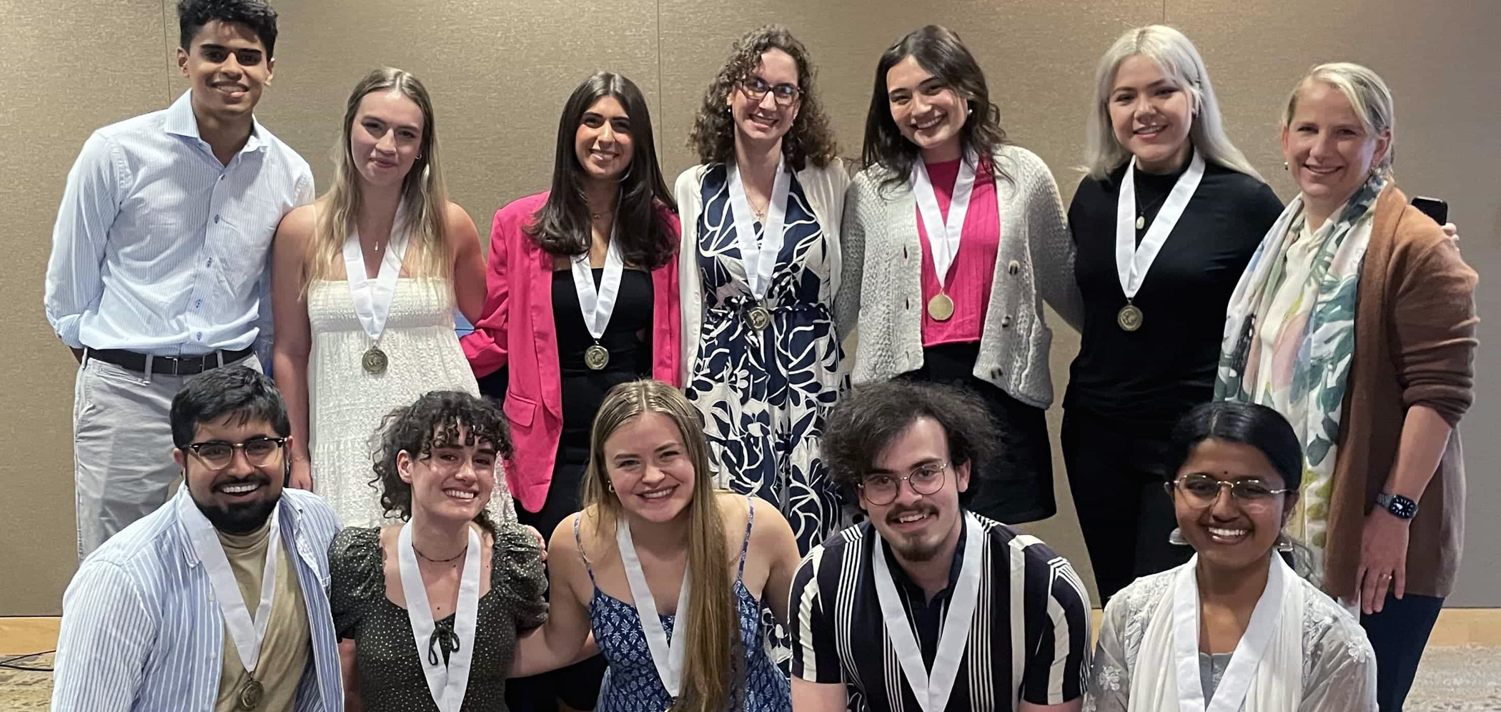 A group of SIS honors students smile as they pose for a group photo.