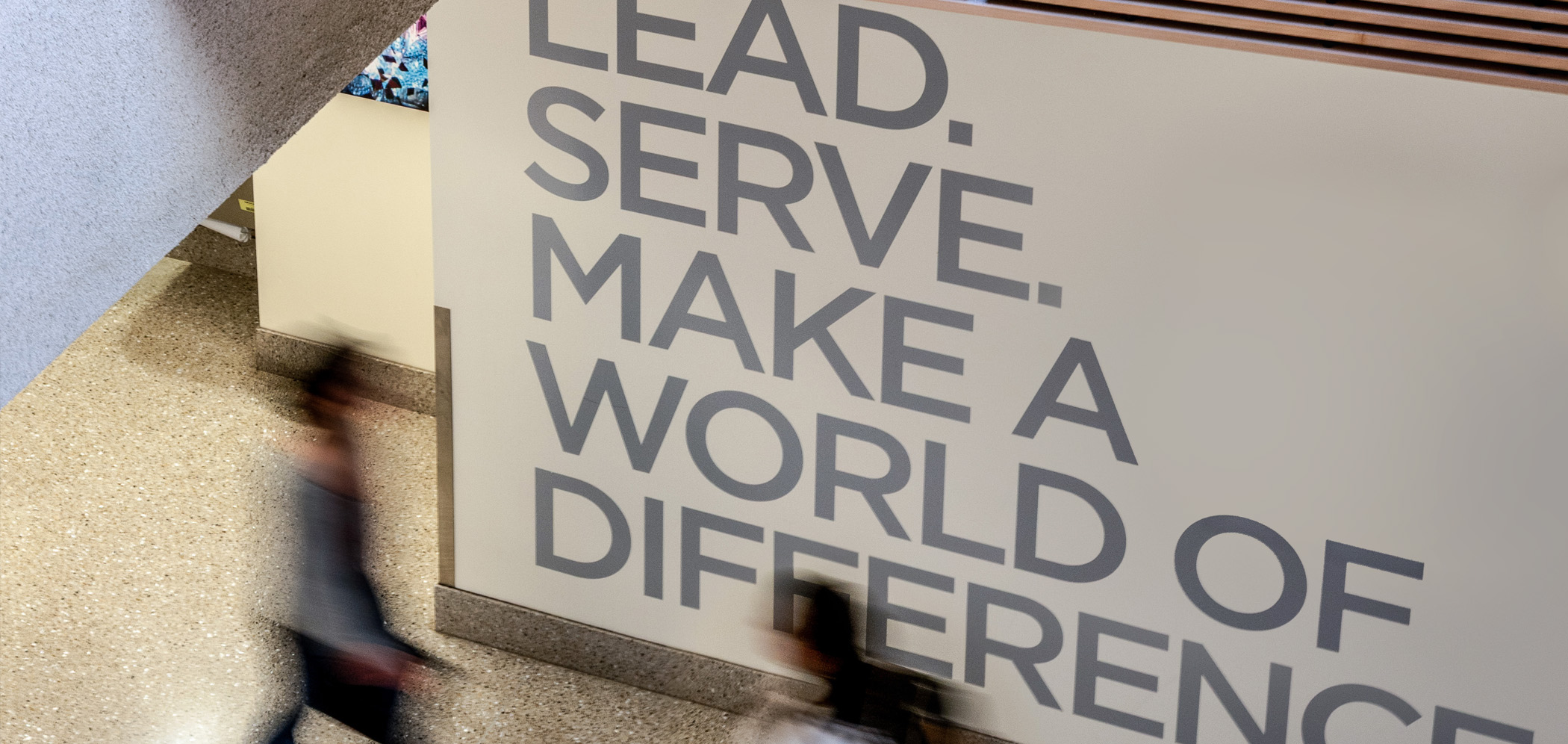 Students walk past a sign that says, Students walk past a sign that says,