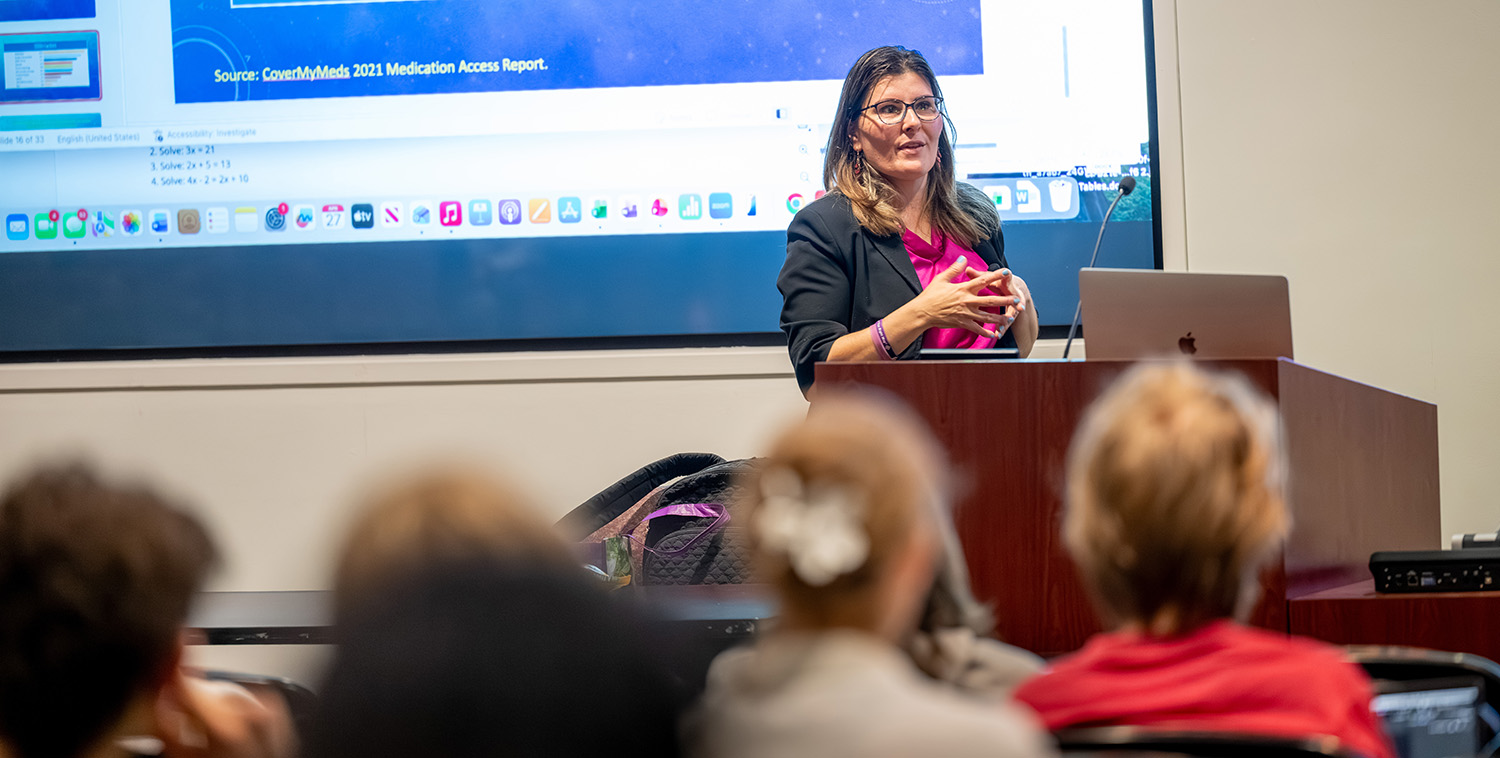 Professor Maria de Jesus lectures in front of a class.