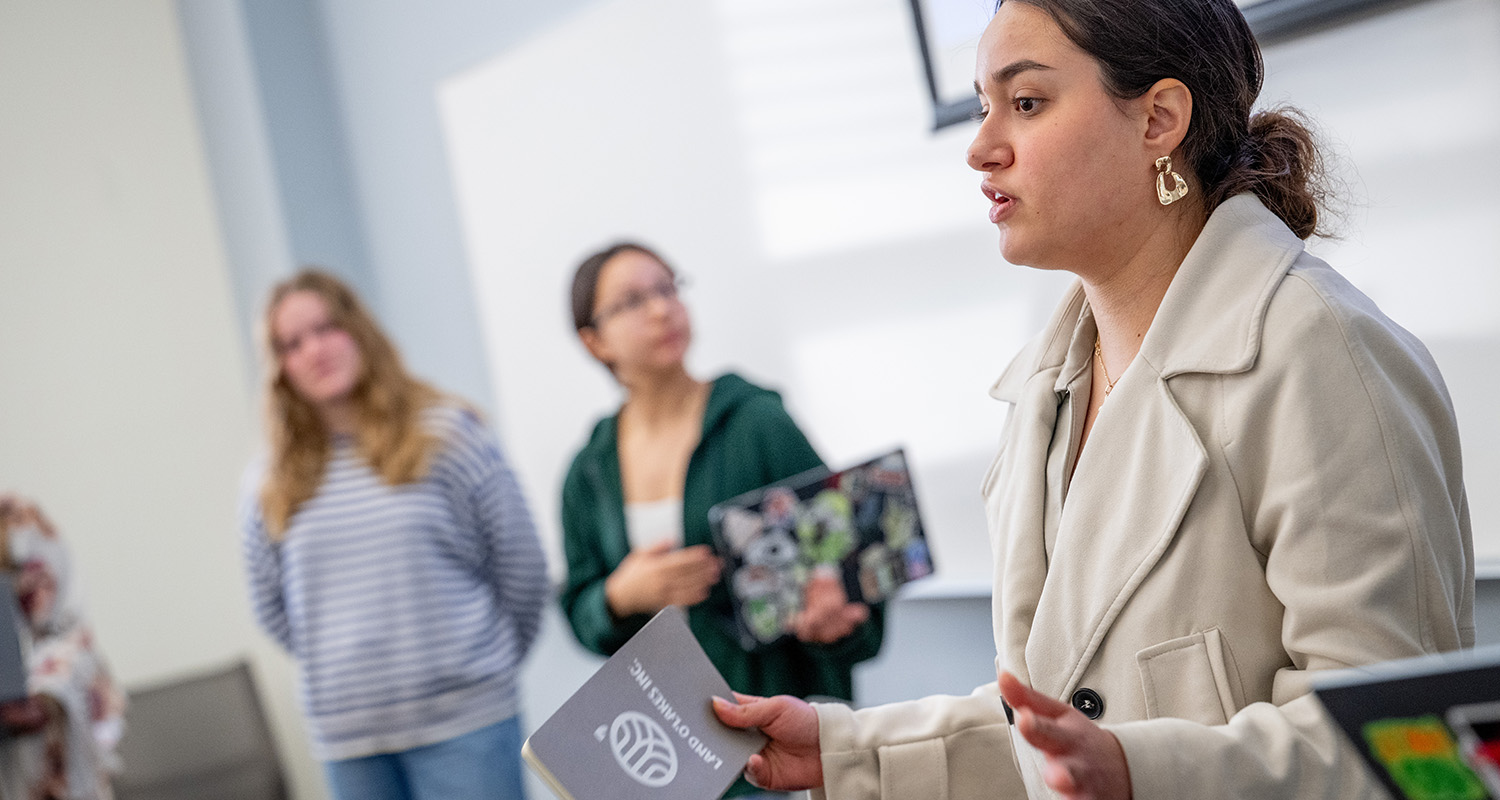 An SIS student gives a presentation at the front of her class.