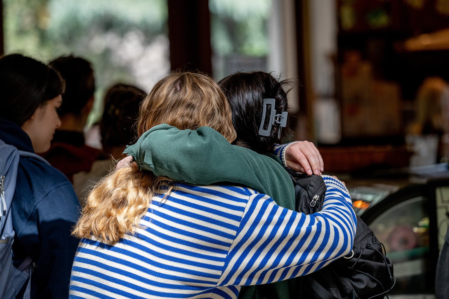 Two friends hug each other outside of the Davenport Lounge.