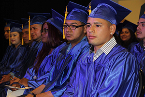 A group of students in graduation robes sitting in chairs