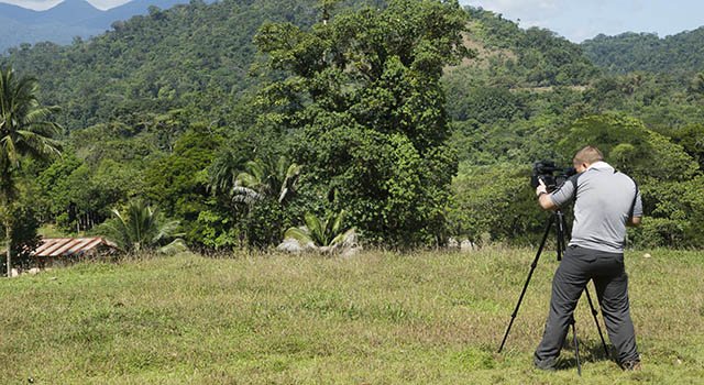 A man films in a tropical climate