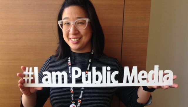 Linda Wei holding a sign that says "I am public media."