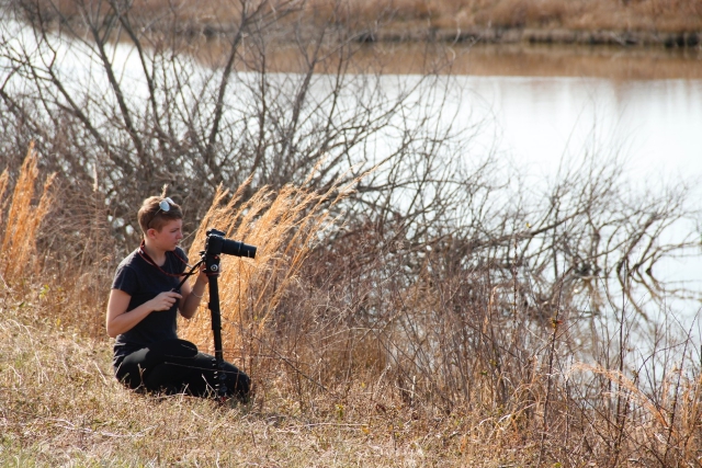 Girl filming near a river.