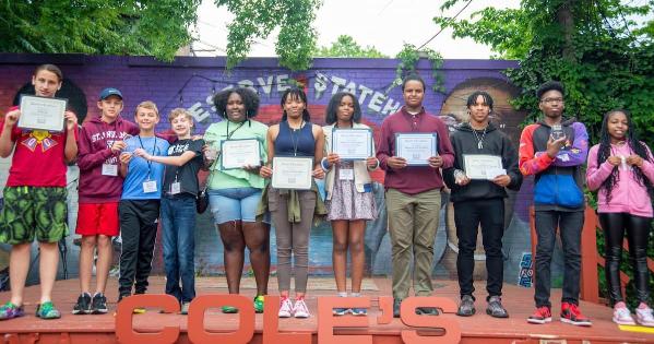 Students hold up their awards at the conclusion of AMYF
