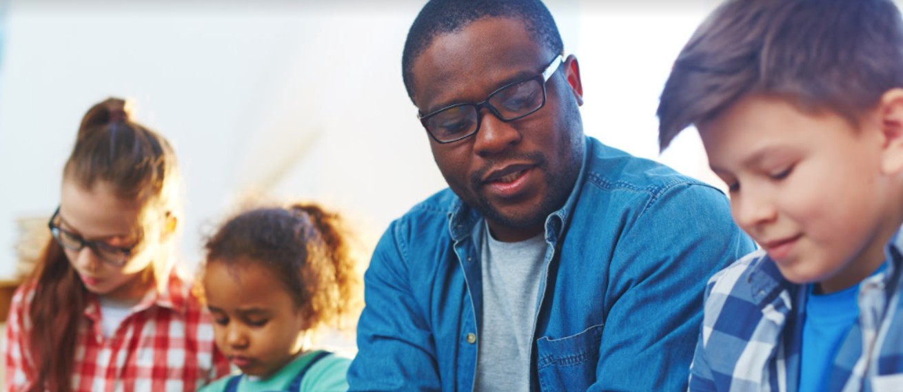 African American teacher with three students of various backgrounds