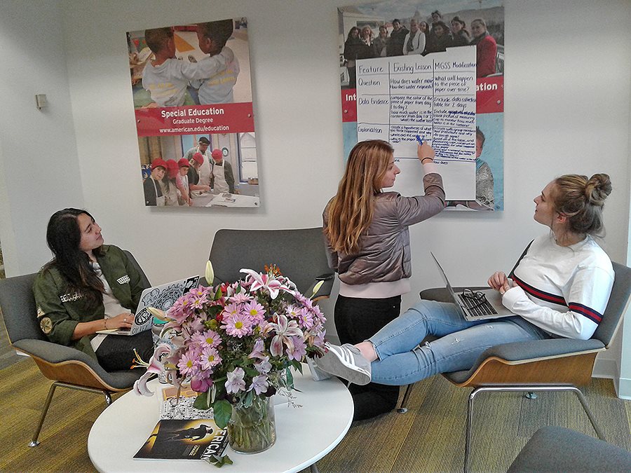 students sitting in the SOE lobby working on a project