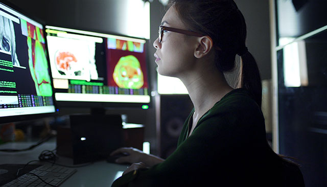 Data scientist looking at computer screens