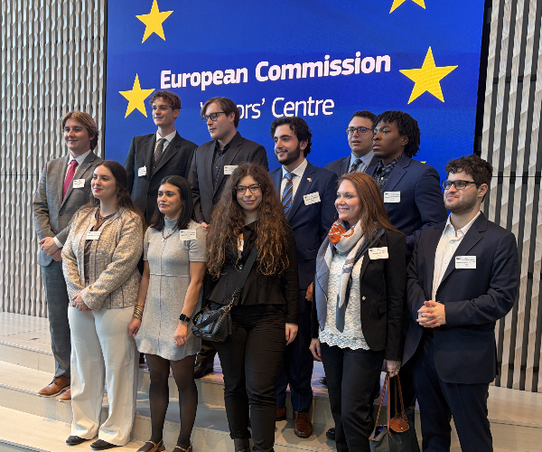 group of students standing in front of EU banner