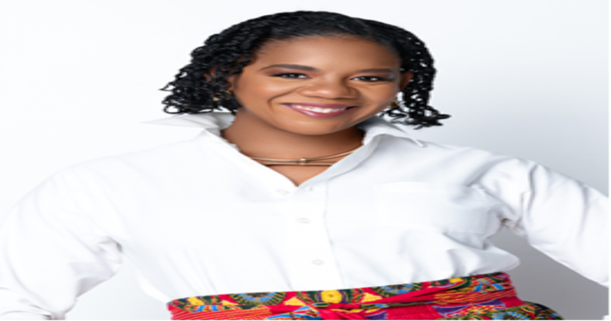 Kelly Crawford, a Black woman stands before a white background wearing a white collared shirt and colorful, patterned skirt