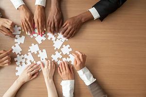 Various hands working on a puzzle
