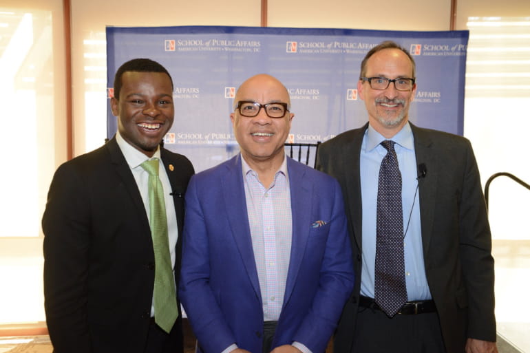 Two people stand with Darren Walker at the event.